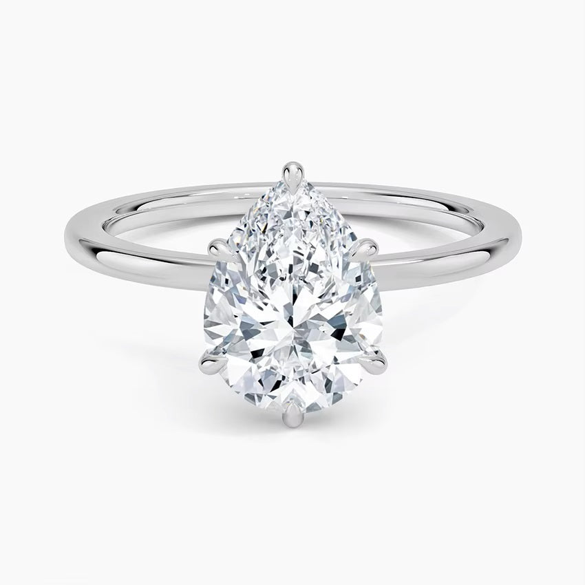 Pear cut Moissanite lab grown diamond engagement ring round shank with a six claw setting, on a gold band, against a white background.Moissanite engagement ring cape town south africa grand diamonds ralph jacobs jeuli