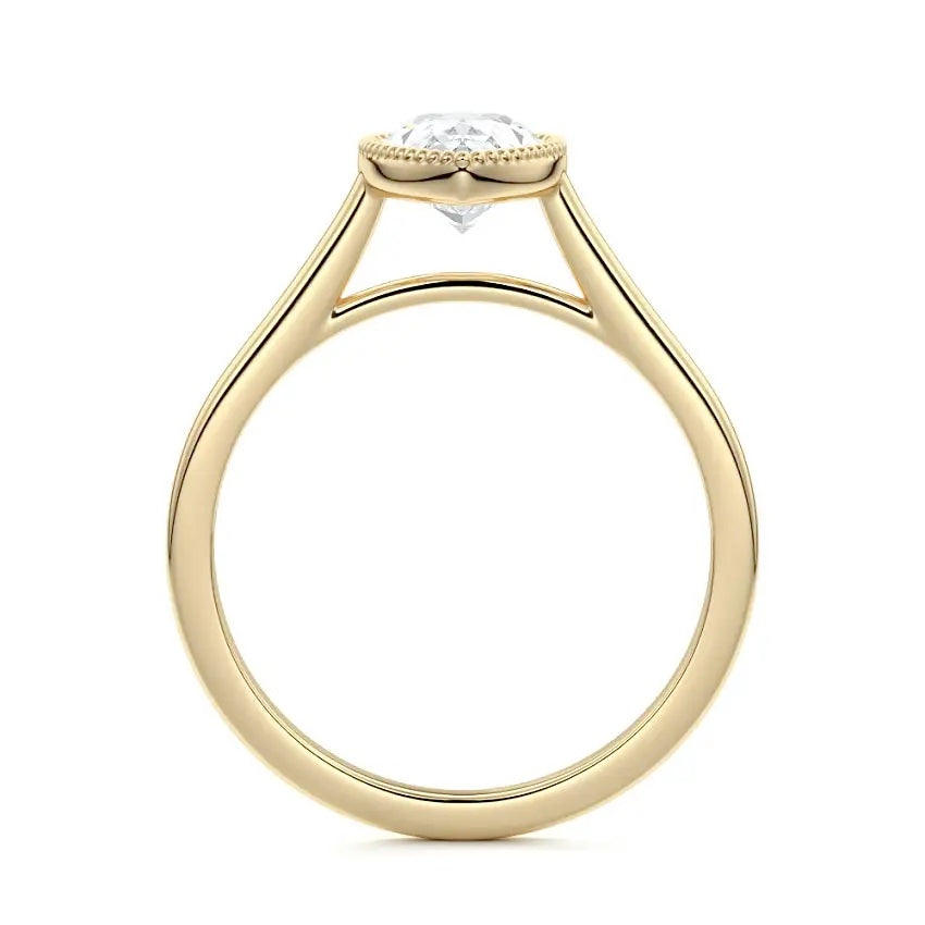 Pear shape Moissanite lab grown diamond engagement ring round shank with a bezel setting, on a gold band, against a white background.Moissanite engagement ring cape town south africa grand diamonds ralph jacobs jeulia 