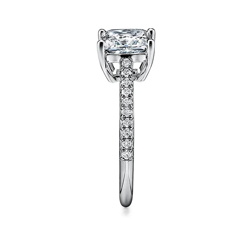Princess cut Moissanite lab grown diamond engagement ring pave set shank with a four claw setting, on a gold band, against a white background.Moissanite engagement ring cape town south africa grand diamonds ralph jacobs jeulia 