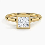Princess cut Moissanite lab grown diamond engagement ring round shank with a bezel setting, on a gold band, against a white background.Moissanite engagement ring cape town south africa grand diamonds ralph jacobs jeulia 