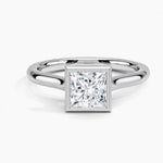 Princess cut Moissanite lab grown diamond engagement ring round shank with a bezel setting, on a gold band, against a white background.Moissanite engagement ring cape town south africa grand diamonds ralph jacobs jeulia 
