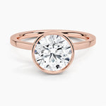 Round cut Moissanite lab grown diamond engagement ring round shank with a bezel setting, on a gold band, against a white background.Moissanite engagement ring cape town south africa grand diamonds ralph jacobs jeulia 