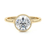 Round cut Moissanite lab grown diamond engagement ring round shank with a bezel setting, on a gold band, against a white background.Moissanite engagement ring cape town south africa grand diamonds ralph jacobs jeulia 