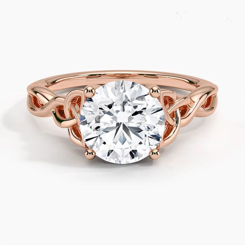 Round cut Moissanite lab grown diamond engagement ring infinity shank with a ornate setting, and intricate basket design on a gold band, against a white background.Moissanite engagement ring cape town south africa grand diamonds ralph jacobs jeuli