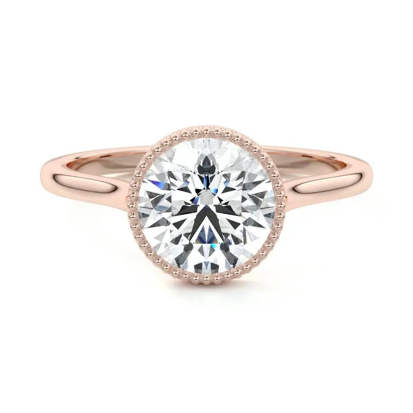 Round cut Moissanite lab grown diamond engagement ring round shank with a bezel setting, on a gold band, against a white background.Moissanite engagement ring cape town south africa grand diamonds ralph jacobs jeulia 