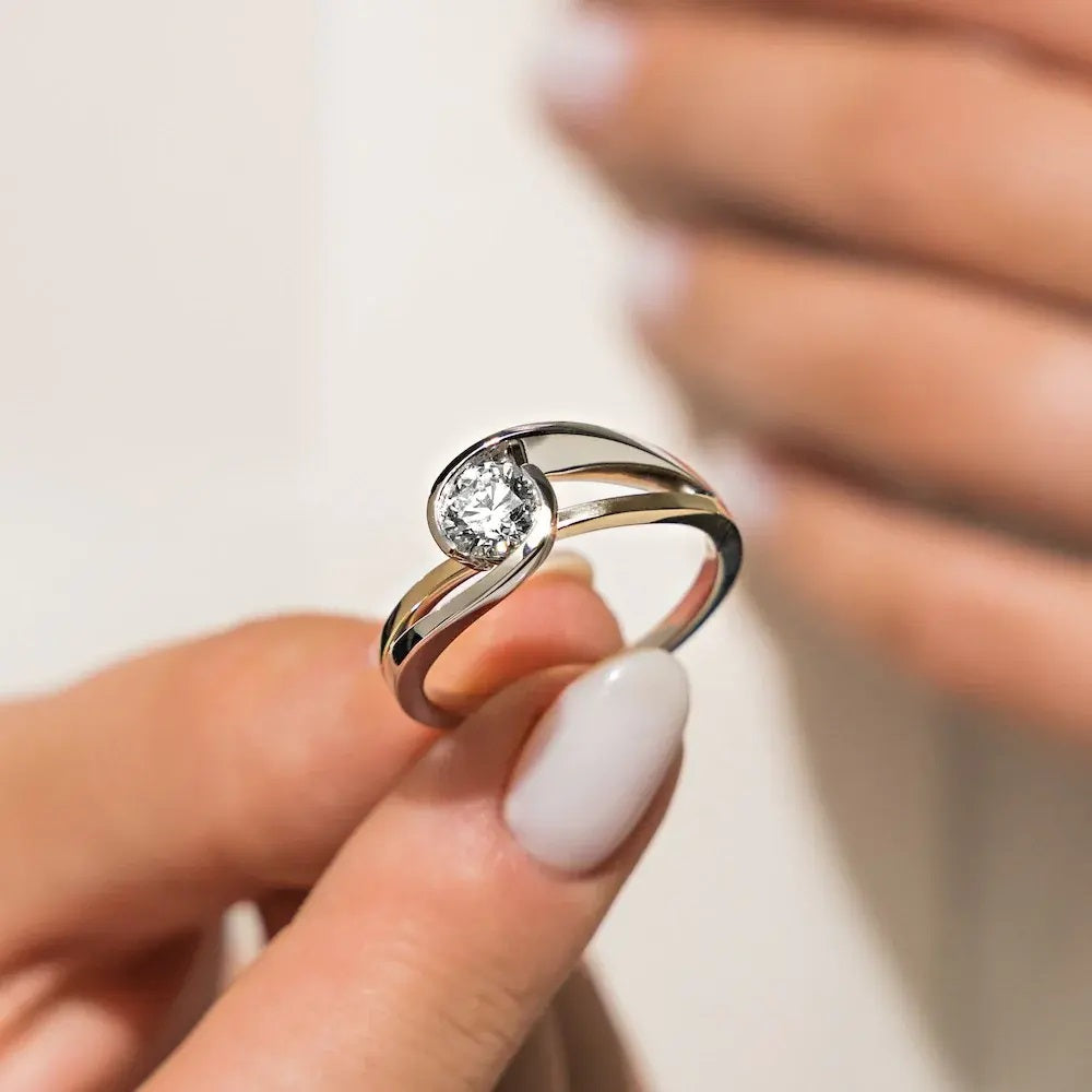 Round cut Moissanite lab grown diamond engagement ring  tension inspired wrap setting, on a two-tone gold band, against a white background.Moissanite engagement ring cape town south africa grand diamonds ralph jacobs jeulia 