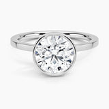 Round cut Moissanite lab grown diamond engagement ring round shank with a bezel setting, on a gold band, against a white background.Moissanite engagement ring cape town south africa grand diamonds ralph jacobs jeulia 