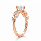 Round cut Moissanite lab grown diamond engagement ring with fancy set small pear moissanite stones on the shank, on a gold band, against a white background.Moissanite engagement ring cape town south africa grand diamonds ralph jacobs jeulia 