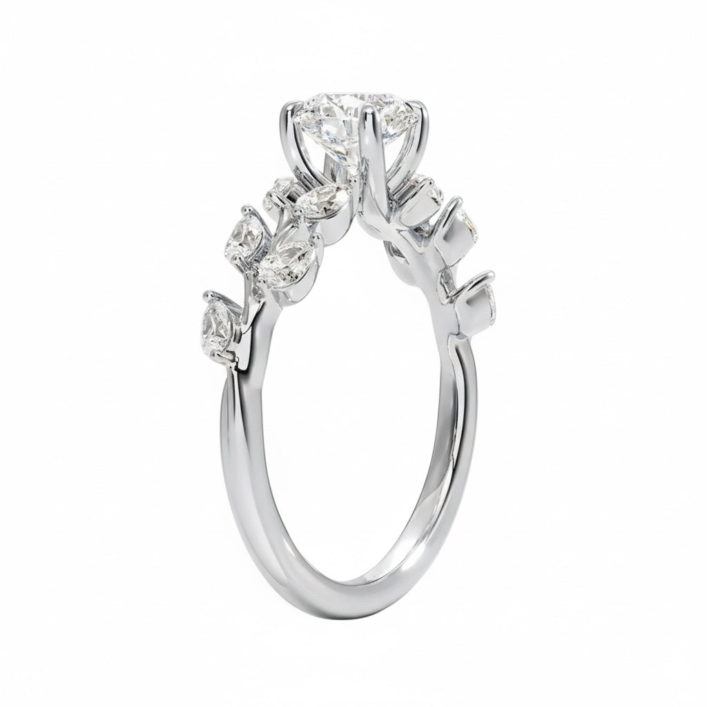 Round cut Moissanite lab grown diamond engagement ring with fancy set small pear moissanite stones on the shank, on a gold band, against a white background.Moissanite engagement ring cape town south africa grand diamonds ralph jacobs jeulia 