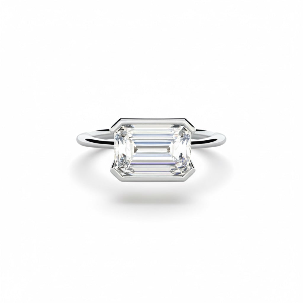 Emerald cut Moissanite lab grown diamond engagement ring column clean sophisticated design on a gold band, against a white background.Moissanite engagement ring cape town south africa grand diamonds ralph jacobs jeuli