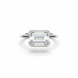 Emerald cut Moissanite lab grown diamond engagement ring column clean sophisticated design on a gold band, against a white background.Moissanite engagement ring cape town south africa grand diamonds ralph jacobs jeuli