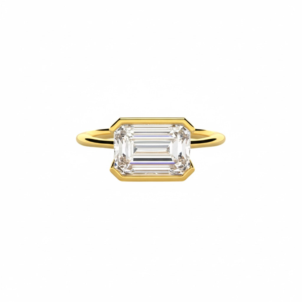 Emerald cut Moissanite lab grown diamond engagement ring column clean sophisticated design on a gold band, against a white background.Moissanite engagement ring cape town south africa grand diamonds ralph jacobs jeuli