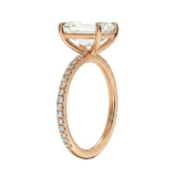 Rose gold ring with a large diamond and smaller diamonds on the band against a white background