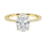 Sculpted four-claw oval cut engagement ring with a tapered pavé yellow gold band ApolloGem.