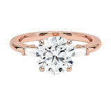 Close up of round brilliant moissanite with tapered baguette accents and four prong setting