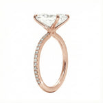 Rose gold ring with a large diamond and smaller diamonds on the band against a white background