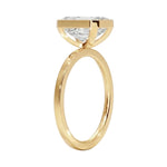 Top-down view of a D-color VVS1 emerald brilliance moissanite in a yellow gold solitaire setting.