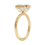 Top-down view of a D-color VVS1 emerald brilliance moissanite in a yellow gold solitaire setting.