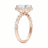 Rose gold ring with a diamond halo and smaller diamonds on a white background