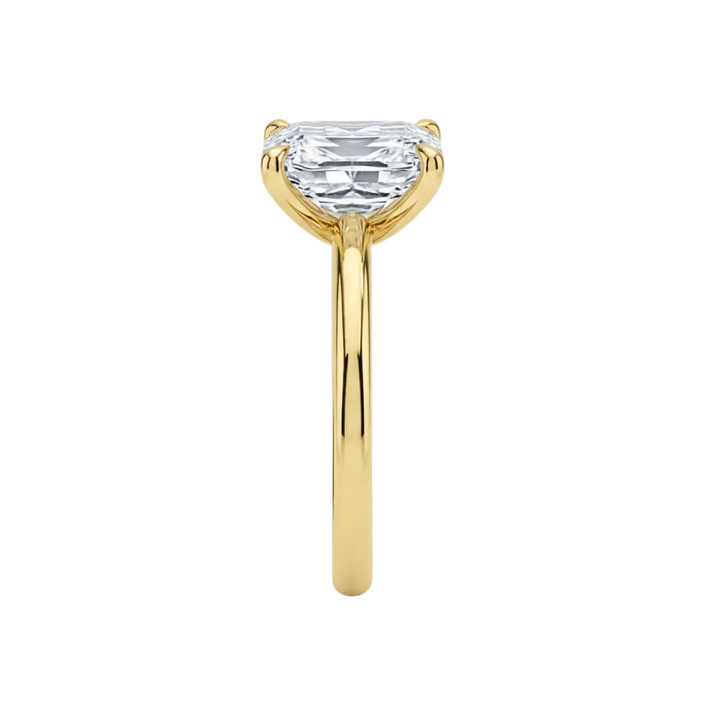 Detailed side view of a four-prong Asscher moissanite ring showing the slim polished gold band.