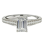 Diamond ring with emerald-cut center stone on a white background