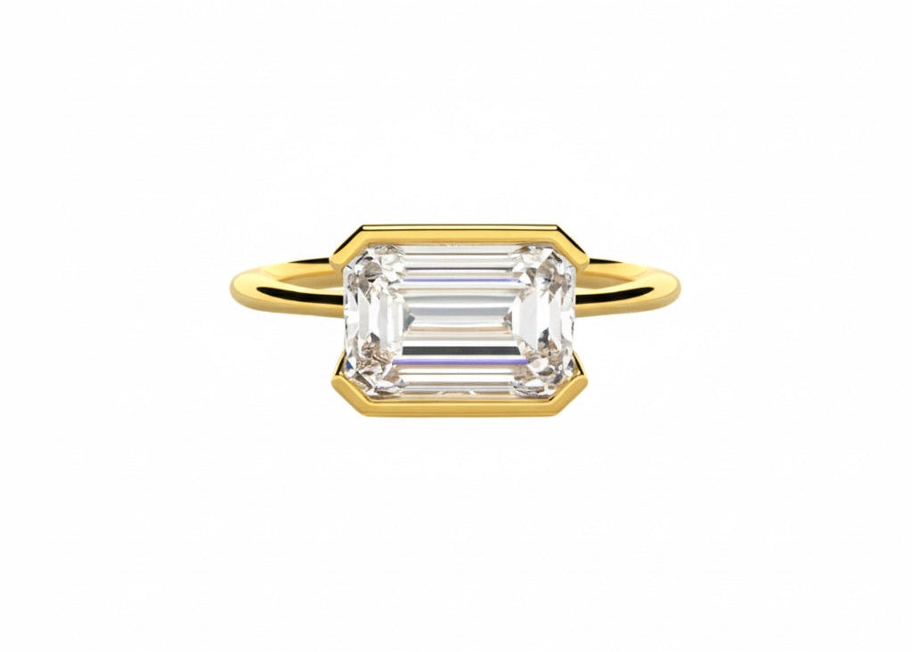Emerald cut moissanite solitaire engagement ring in a modern East-West column setting ApolloGem.