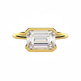 Emerald cut moissanite solitaire engagement ring in a modern East-West column setting ApolloGem.