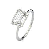Symmetrical top-down view of an emerald moissanite horizontally set on a polished gold band.