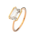 Symmetrical top-down view of an emerald moissanite horizontally set on a polished gold band.