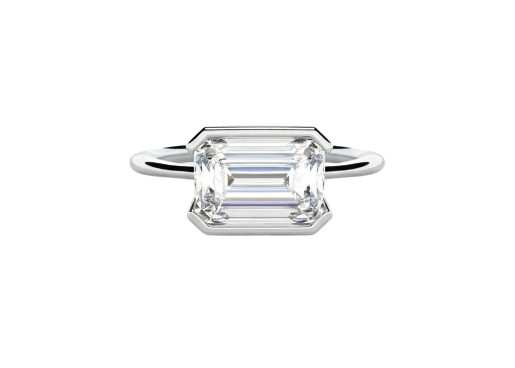 Emerald cut moissanite solitaire engagement ring in a modern East-West column setting ApolloGem.