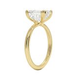 Detailed side view of an emerald moissanite ring showing the double cat-claw prongs and slim polished band.