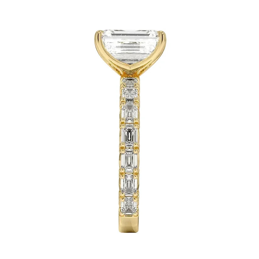 Top-down view of a symmetrical emerald cut moissanite ring on a luxurious step-cut eternity gold band.