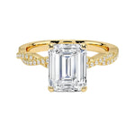 Four-claw emerald cut moissanite engagement ring with a pavé infinity twist vine band in yellow gold ApolloGem.