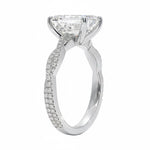 Side profile of the Emerald Infinity Twist ring showing the interlocking smooth and pavé-set gold bands.
