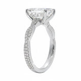 Side profile of the Emerald Infinity Twist ring showing the interlocking smooth and pavé-set gold bands.