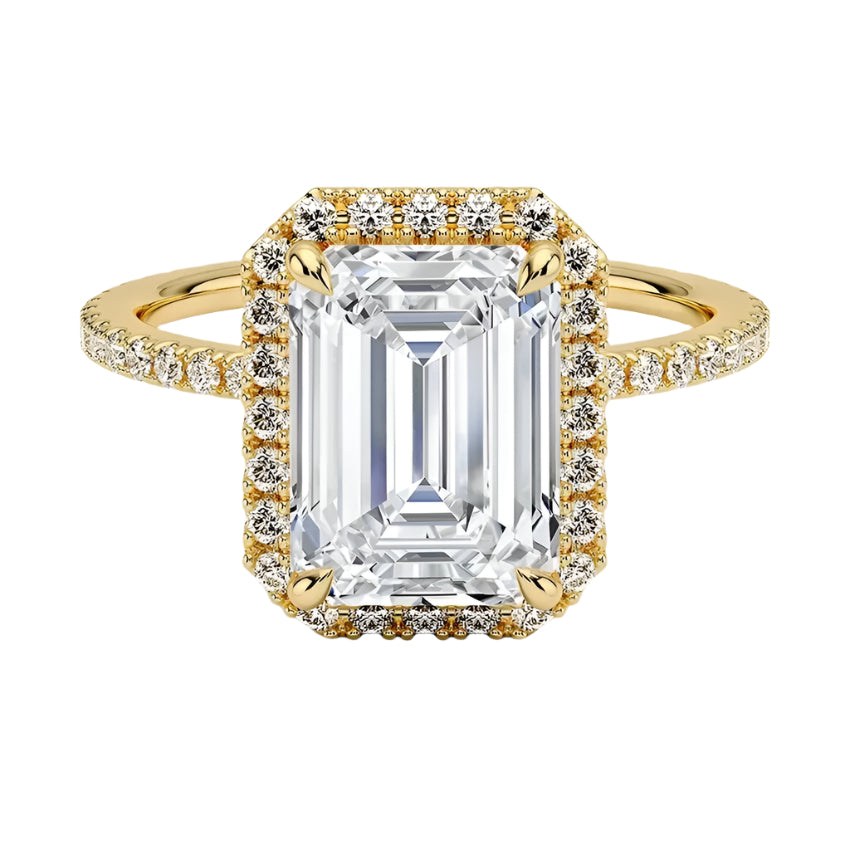 An emerald-cut halo moissanite engagement ring with a pave band, featuring a large central stone surrounded by smaller stones set in a gold metal band.