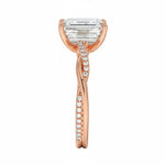 Top-down view of a D-color VVS1 emerald stone in an asymmetrical rose gold infinity setting.