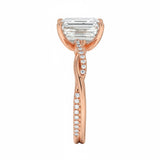 Top-down view of a D-color VVS1 emerald stone in an asymmetrical rose gold infinity setting.