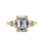 Grand emerald cut moissanite engagement ring in a heavy three-stone solid gold setting ApolloGem.