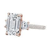 Close-up of a high-quality D-color VVS1 emerald moissanite center stone with structural trapezoid accents in solid gold.
