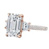 Close-up of a high-quality D-color VVS1 emerald moissanite center stone with structural trapezoid accents in solid gold.