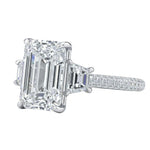 Luxury emerald cut moissanite engagement ring with trapezoid side stones and triple-row pavé band in white gold ApolloGem.