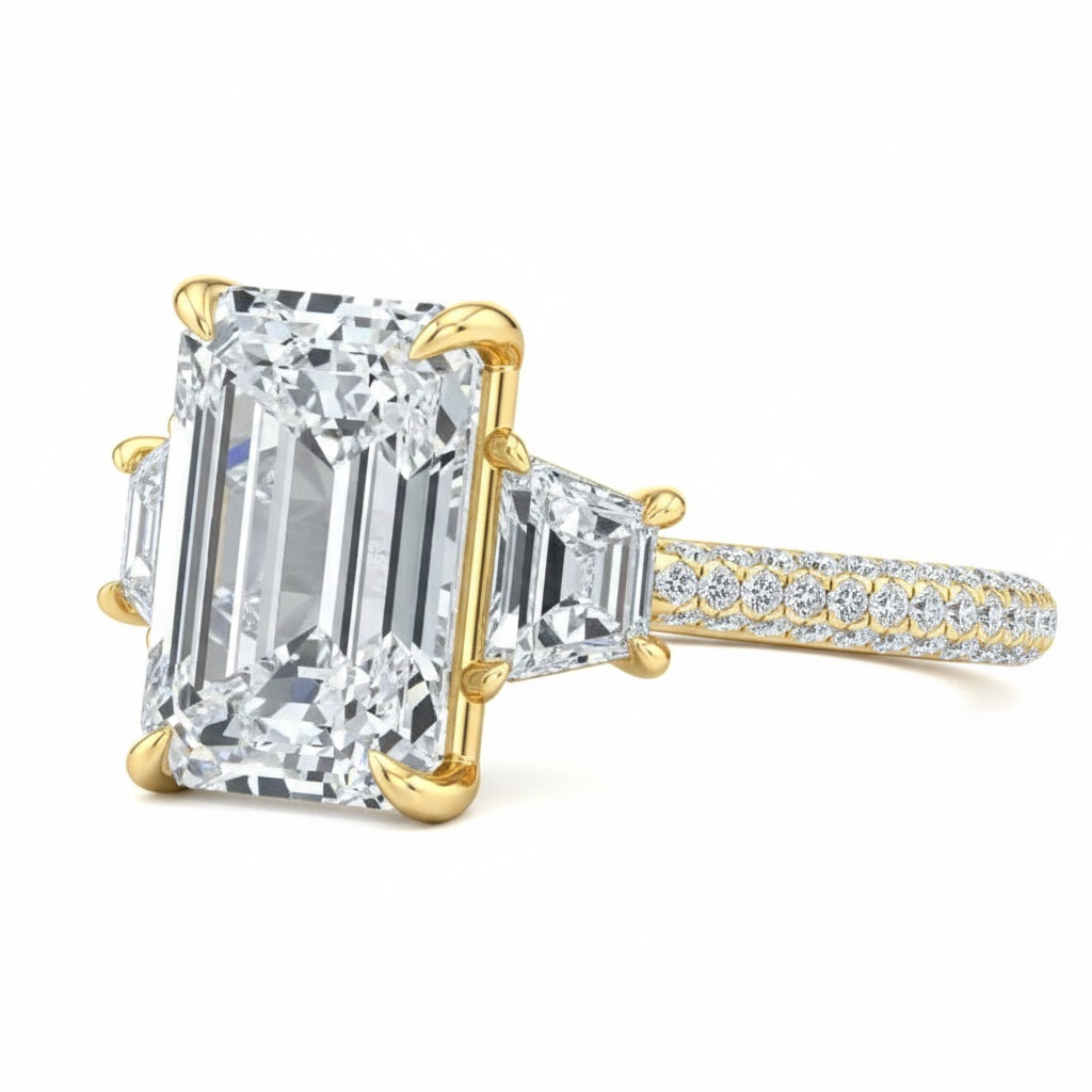 Luxury emerald cut moissanite engagement ring with trapezoid side stones and triple-row pavé band in yellow gold ApolloGem.