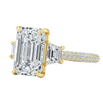 Luxury emerald cut moissanite engagement ring with trapezoid side stones and triple-row pavé band in yellow gold ApolloGem.