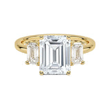 Grand emerald cut moissanite trilogy engagement ring in yellow gold ApolloGem.