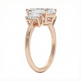 Detailed side view showing the architectural basket settings for the three-stone emerald ring.