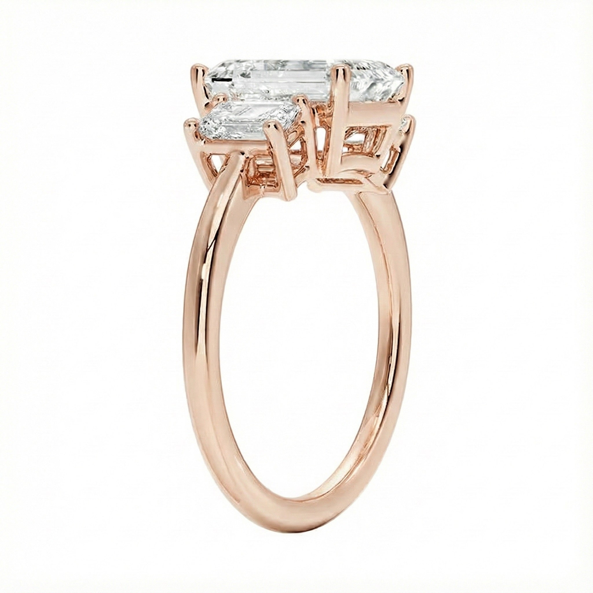 Detailed side view showing the architectural basket settings for the three-stone emerald ring.