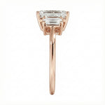 Symmetrical top-down view of a graduated triple emerald-cut moissanite ring in polished solid gold.