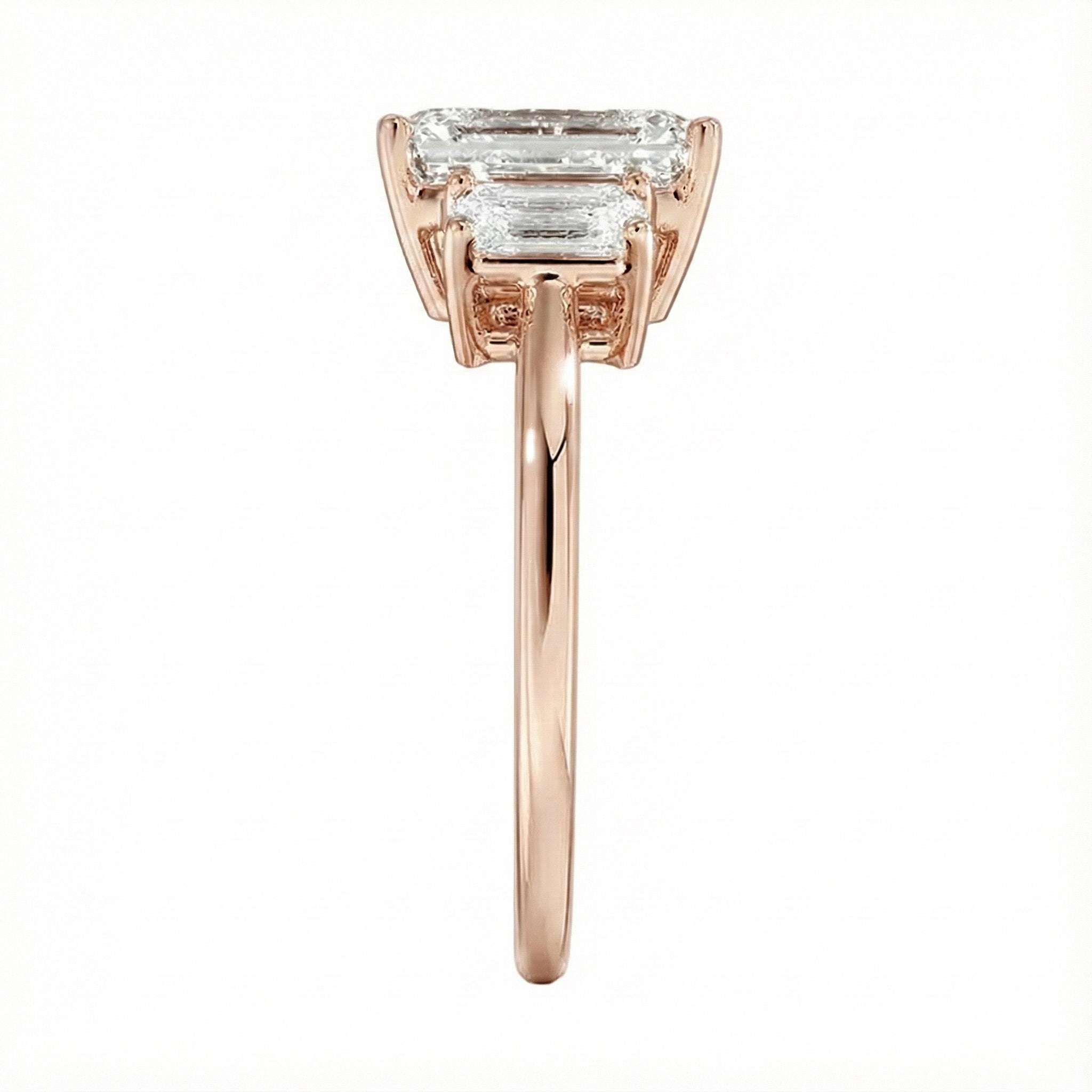 Symmetrical top-down view of a graduated triple emerald-cut moissanite ring in polished solid gold.