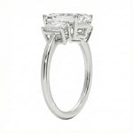 Detailed side view showing the architectural basket settings for the three-stone emerald ring.